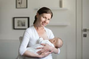 Mutter stillt Baby mit Muttermilch
